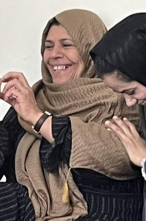 An Iraqi midwife in a tan hijab laughing during a Midwives @ the Edges training session.