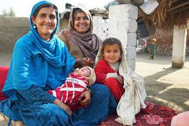 Three generations of Pakistani women sharing a newborn.